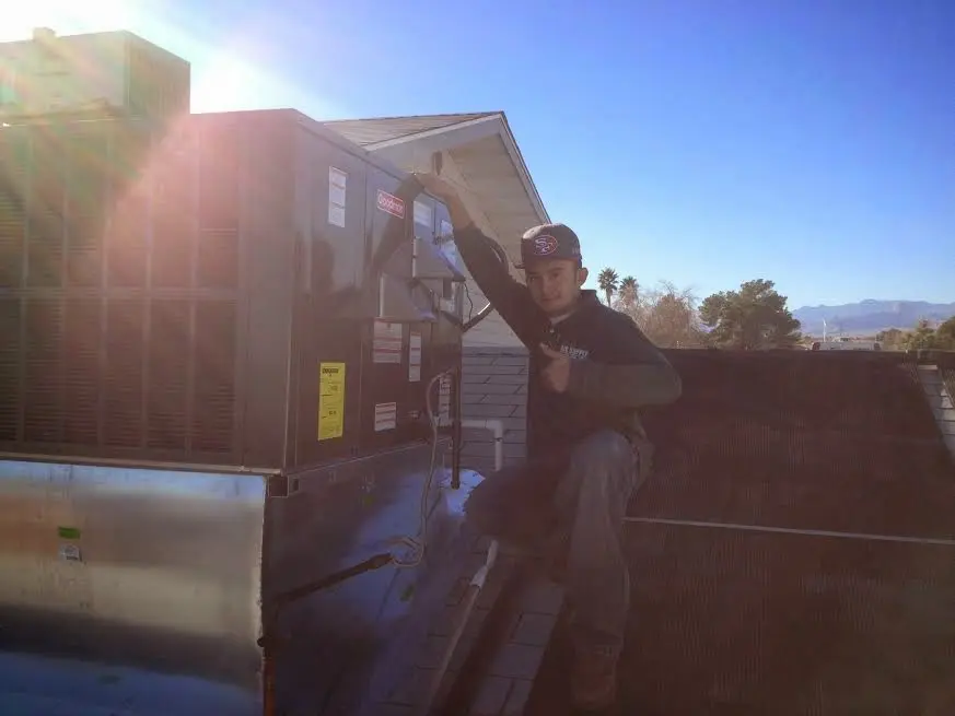 HVAC technician performing HVAC Inspection on a rooftop unit in Grafton